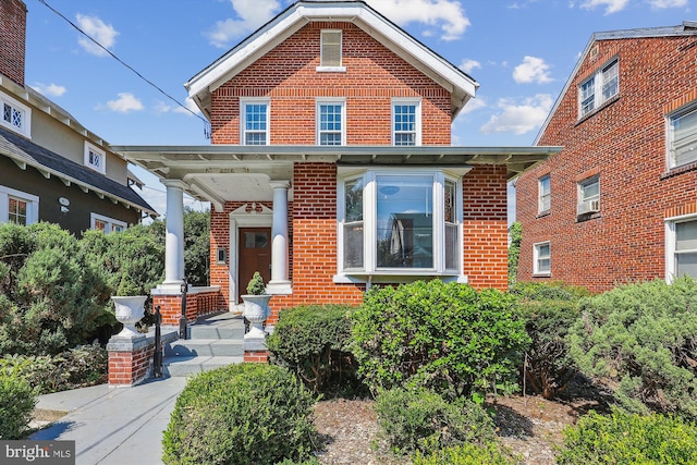 view of front of home with covered porch and brick siding