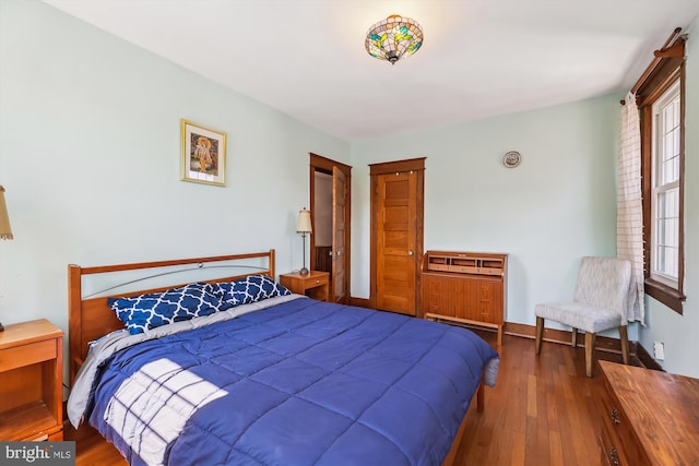 bedroom with hardwood / wood-style flooring and baseboards