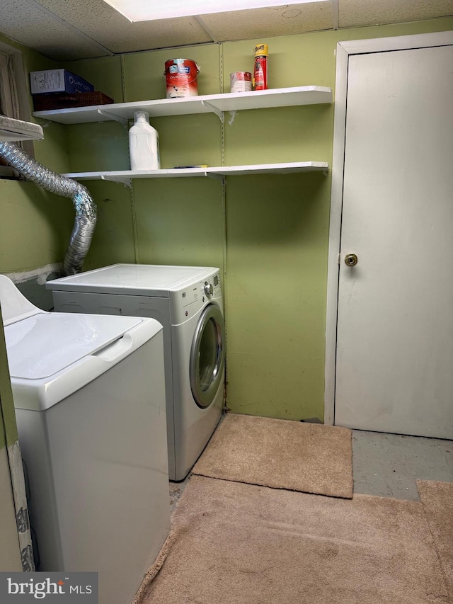 clothes washing area featuring laundry area and washer and clothes dryer