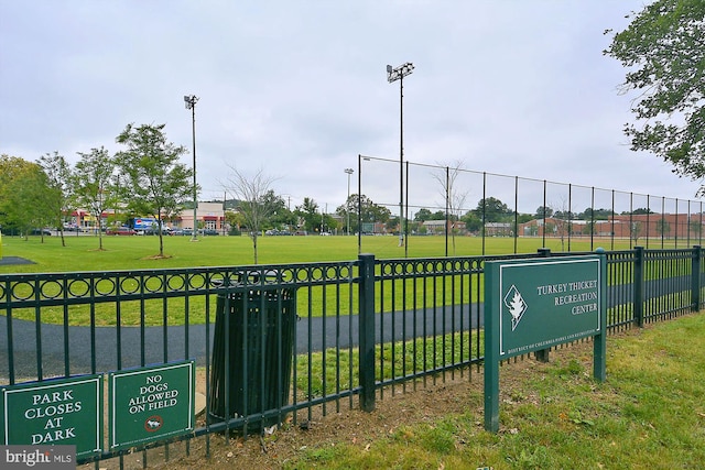 view of home's community with a yard and fence