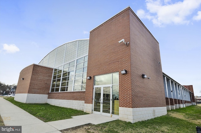 view of property exterior featuring a lawn and brick siding