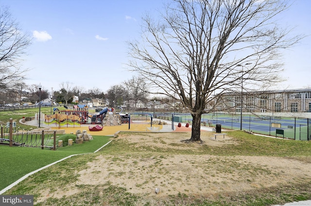 view of property's community with a tennis court, playground community, and fence