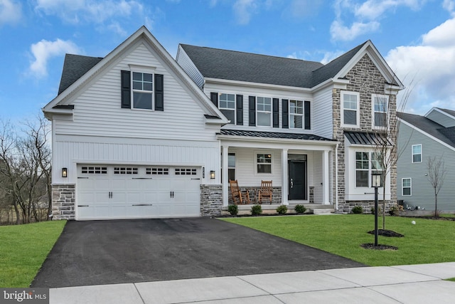 view of front of property with aphalt driveway, covered porch, a front yard, a garage, and stone siding