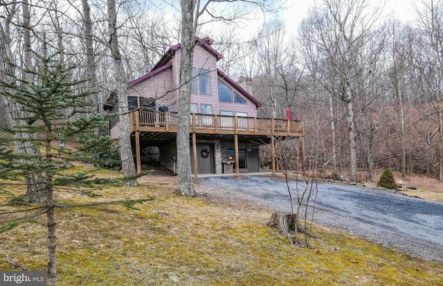 view of front facade with a deck and dirt driveway