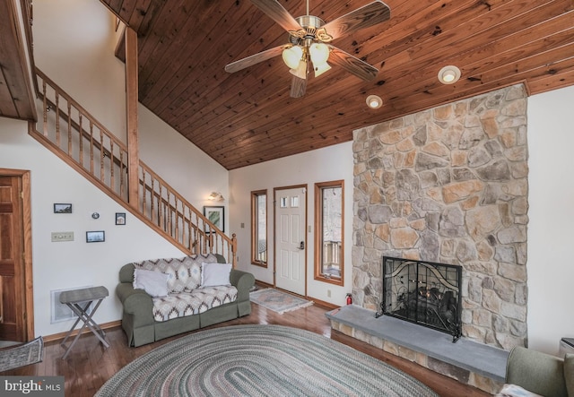 living area with ceiling fan, stairway, baseboards, and wood finished floors