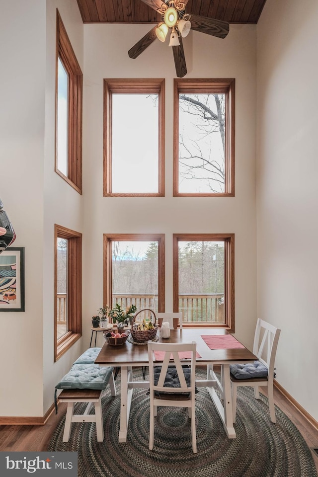 dining area with a wealth of natural light, baseboards, wood finished floors, and ceiling fan