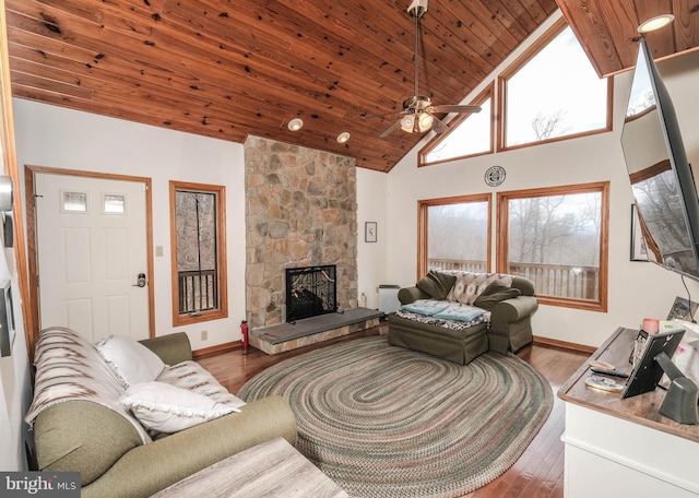 living area with wood ceiling, a fireplace, wood finished floors, high vaulted ceiling, and a ceiling fan