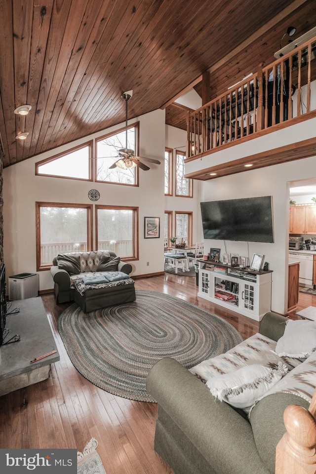 living room featuring baseboards, wood ceiling, hardwood / wood-style flooring, high vaulted ceiling, and a ceiling fan