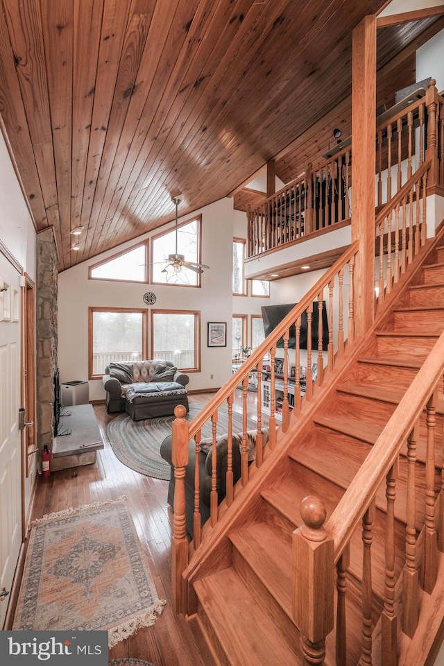 stairs with ceiling fan, high vaulted ceiling, hardwood / wood-style floors, and wooden ceiling