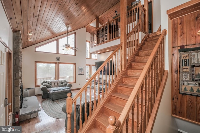 staircase with a ceiling fan, wood finished floors, wood ceiling, and high vaulted ceiling