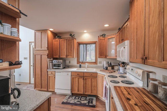 kitchen with a sink, recessed lighting, white appliances, and open shelves