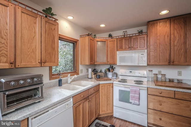 kitchen featuring a sink, recessed lighting, white appliances, brown cabinetry, and a toaster