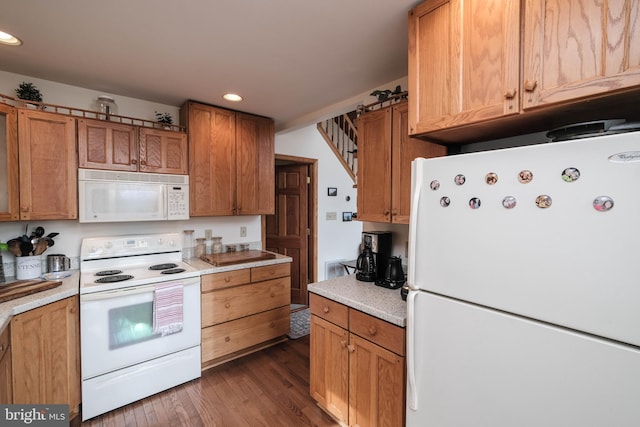 kitchen with recessed lighting, white appliances, wood finished floors, and brown cabinetry