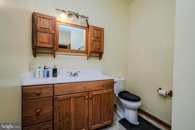 bathroom with vanity, toilet, and baseboards