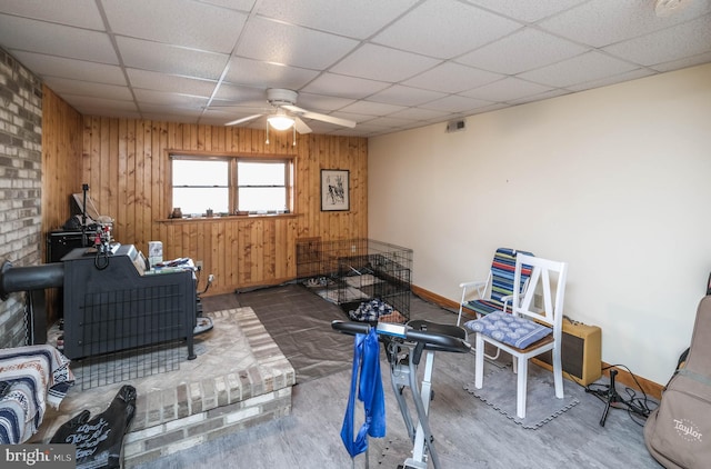 interior space featuring wood finished floors, a paneled ceiling, ceiling fan, and wood walls