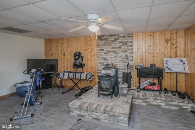 interior space with wooden walls, a paneled ceiling, and a ceiling fan