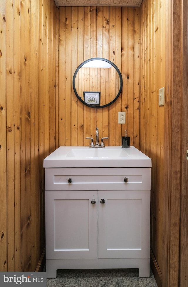 bathroom featuring vanity and wood walls