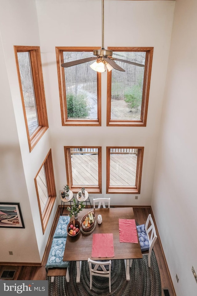 dining space with a wealth of natural light, visible vents, a ceiling fan, and wood finished floors