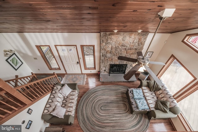 living room featuring a fireplace, wood ceiling, ceiling fan, and wood finished floors