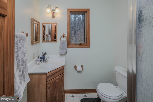 bathroom with tile patterned flooring, toilet, vanity, and baseboards