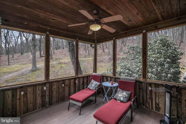 sunroom / solarium with plenty of natural light, wood ceiling, and a ceiling fan