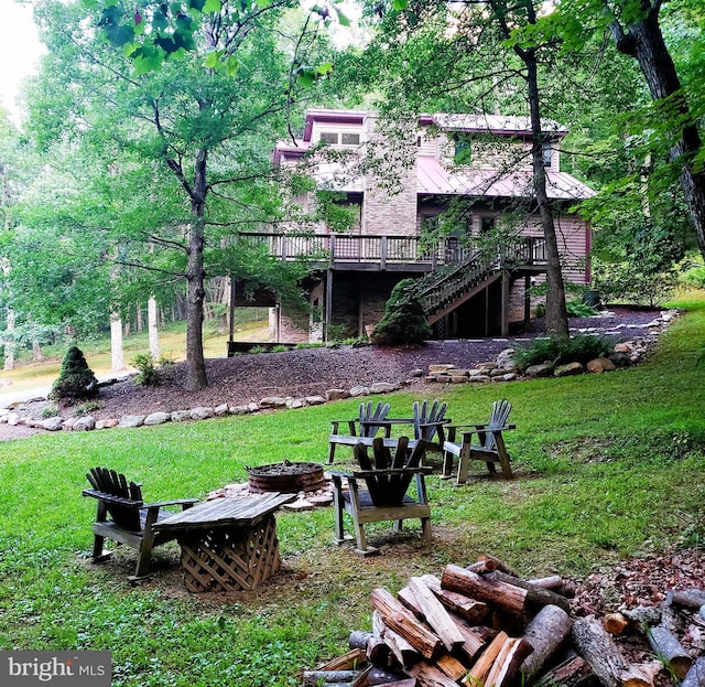 view of yard with stairway, an outdoor fire pit, and a deck