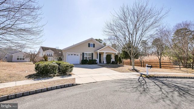 view of front of property featuring concrete driveway, covered porch, fence, and an attached garage