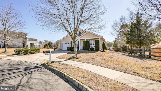 view of front facade featuring driveway, an attached garage, and fence