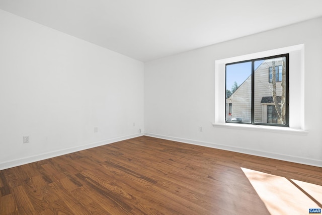 unfurnished room with baseboards and wood finished floors