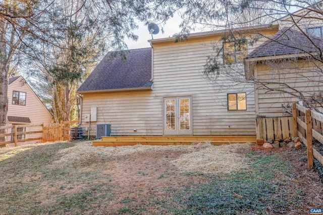 rear view of property with central AC, french doors, a shingled roof, and fence