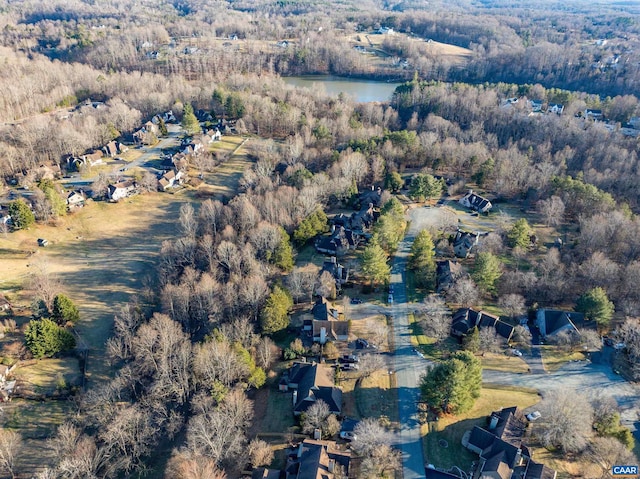 drone / aerial view with a water view and a forest view