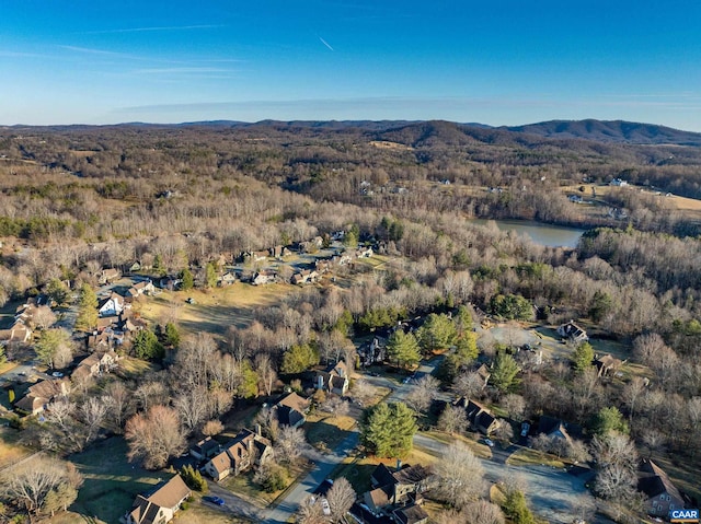 drone / aerial view with a forest view and a water and mountain view