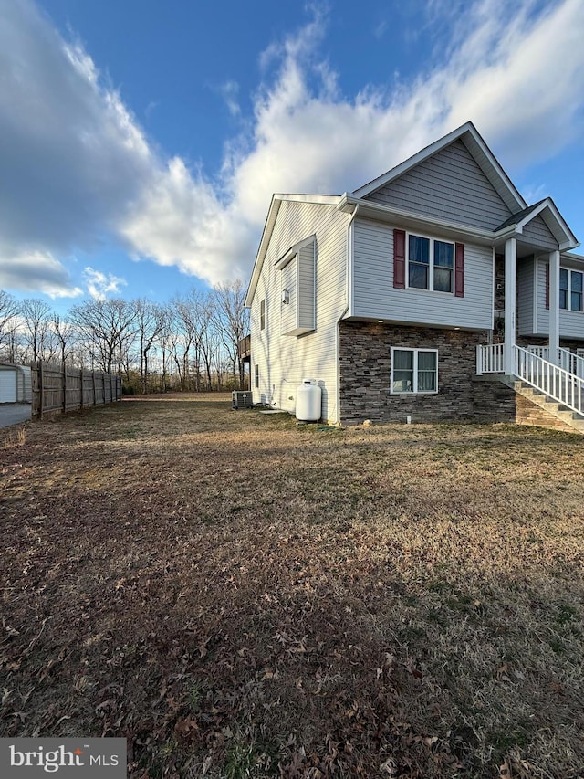 view of side of home with stone siding and cooling unit