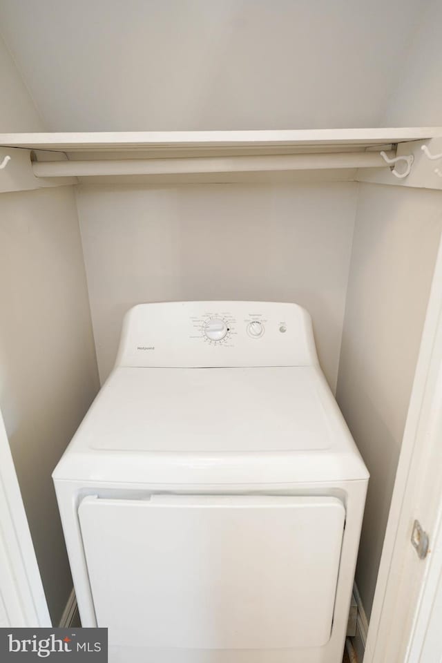 clothes washing area featuring washer / clothes dryer, baseboards, and laundry area