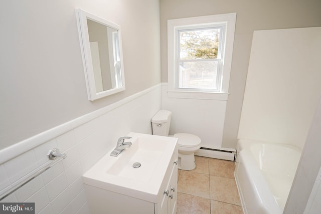 bathroom featuring wainscoting, toilet, tile patterned flooring, baseboard heating, and tile walls