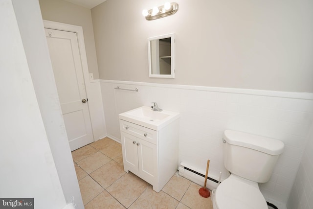 bathroom with toilet, a baseboard heating unit, wainscoting, vanity, and tile patterned floors