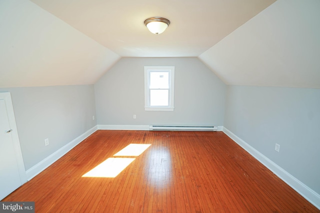 bonus room featuring lofted ceiling, baseboards, baseboard heating, and hardwood / wood-style flooring