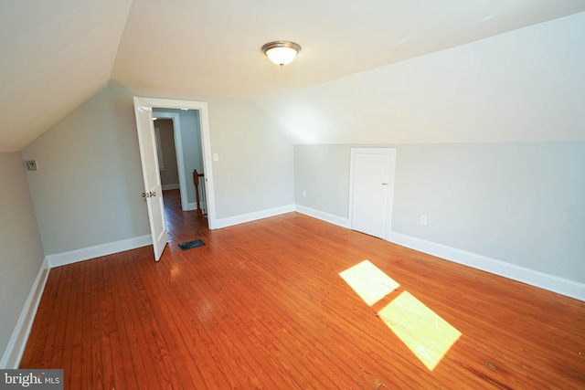 bonus room featuring visible vents, vaulted ceiling, baseboards, and hardwood / wood-style flooring