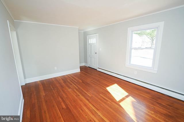 spare room with ornamental molding, a baseboard radiator, wood finished floors, and baseboards