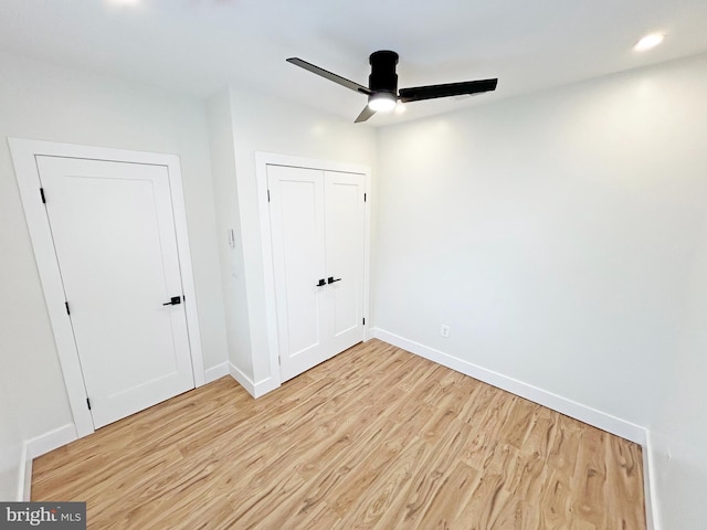 unfurnished bedroom with ceiling fan, a closet, light wood-type flooring, and baseboards