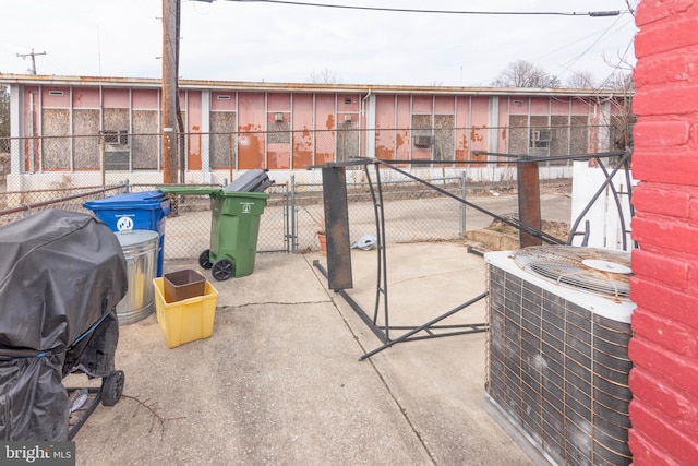 view of patio featuring a gate, fence, and central AC unit