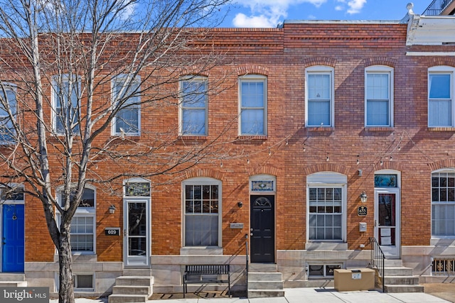 view of property featuring entry steps and brick siding