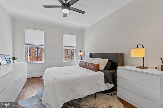 bedroom featuring a ceiling fan, baseboards, ornamental molding, and wood finished floors