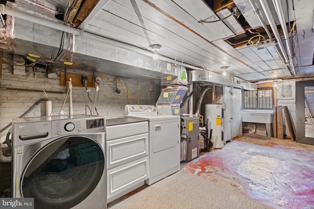 laundry area with water heater, laundry area, and washer and dryer