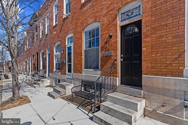 view of exterior entry with brick siding