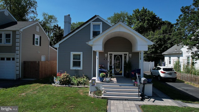 bungalow featuring covered porch, fence, a chimney, and a front lawn