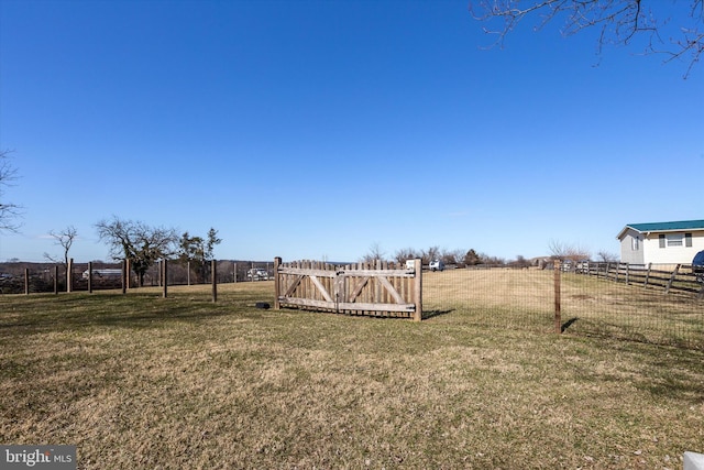 view of yard featuring a gate, a rural view, and fence