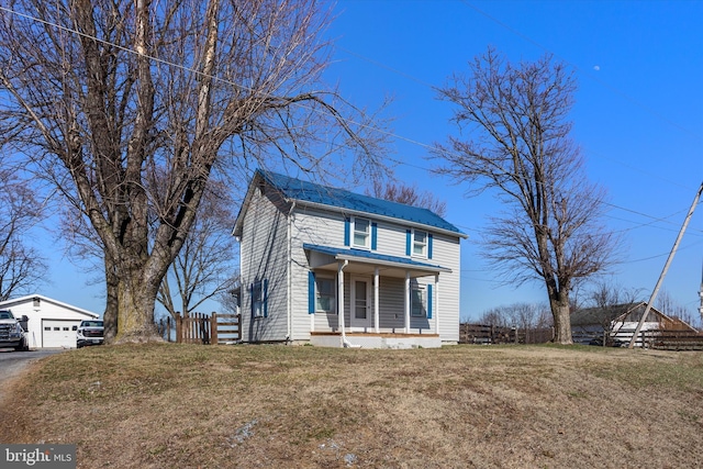 view of front of property with a front lawn, fence, a porch, and an outbuilding