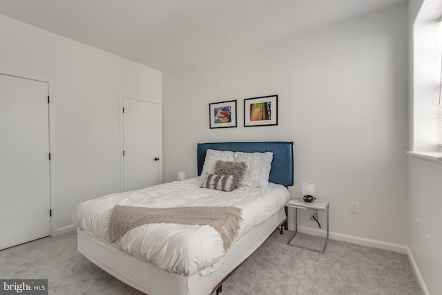 bedroom with carpet floors, multiple windows, and baseboards