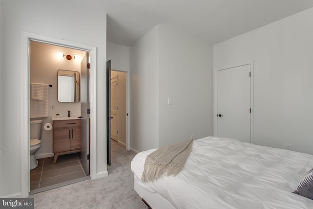 bedroom with carpet floors, ensuite bath, and baseboards